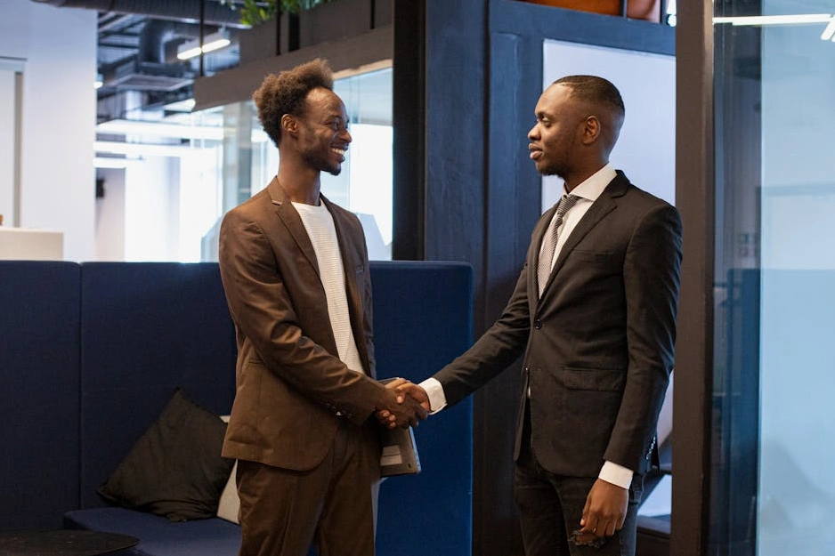 Consulente che stringe la mano a un cliente in un ufficio moderno.